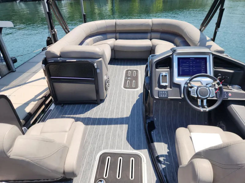 Slide: The Image of 2023 Premier 250 Intrigue RL pontoon boat interior with plush seating and modern dashboard. - 12