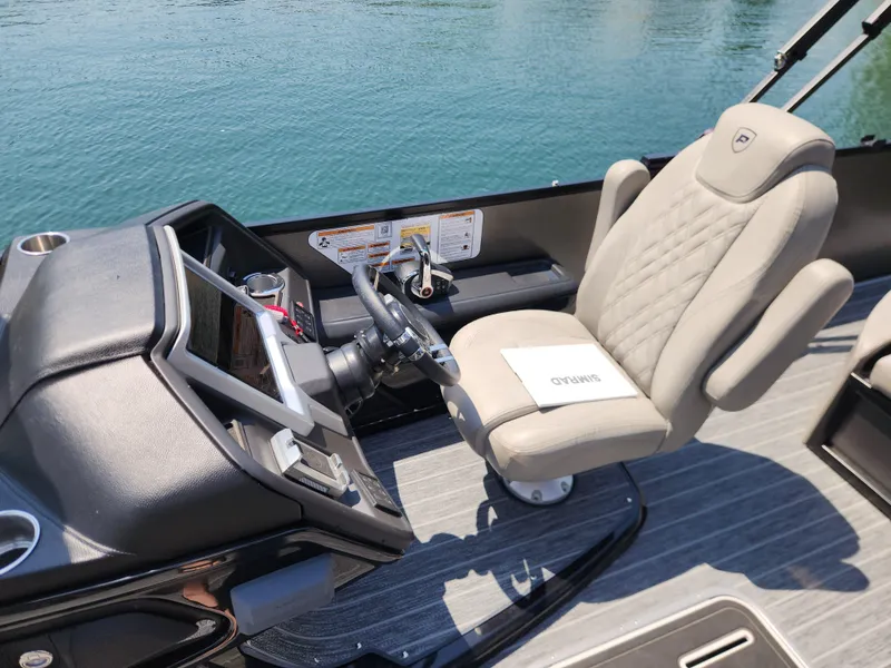 Slide: The Image of Captain's seat and helm of 2023 Premier 250 Intrigue RL boat on water. - 15