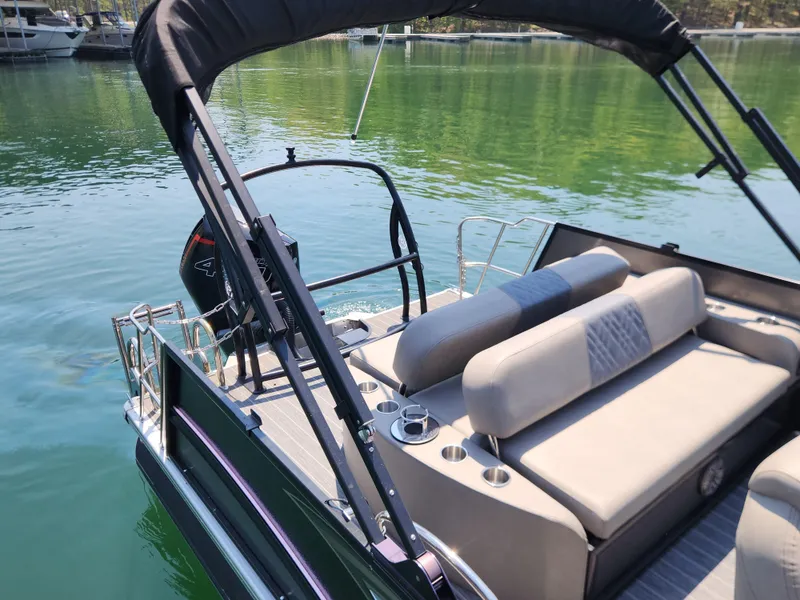 Slide: The Image of 2023 Premier 250 Intrigue RL pontoon boat with seating, on a calm lake. - 4