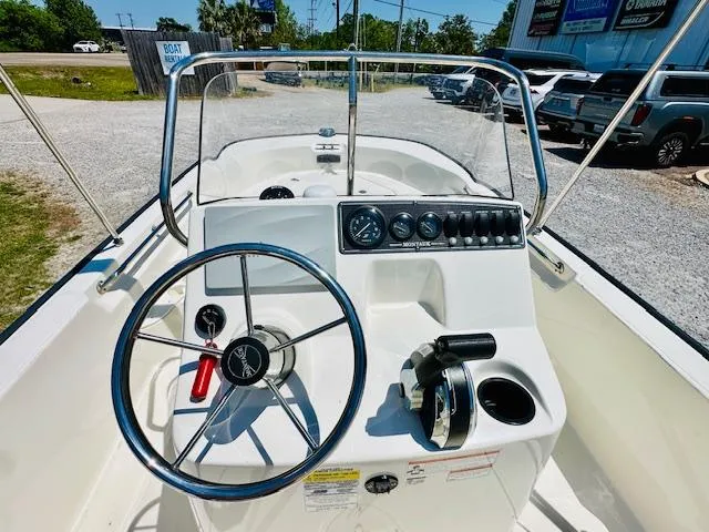 Slide: The Image of 2018 Boston Whaler 170 Montauk boat dashboard with steering wheel and controls. - 13