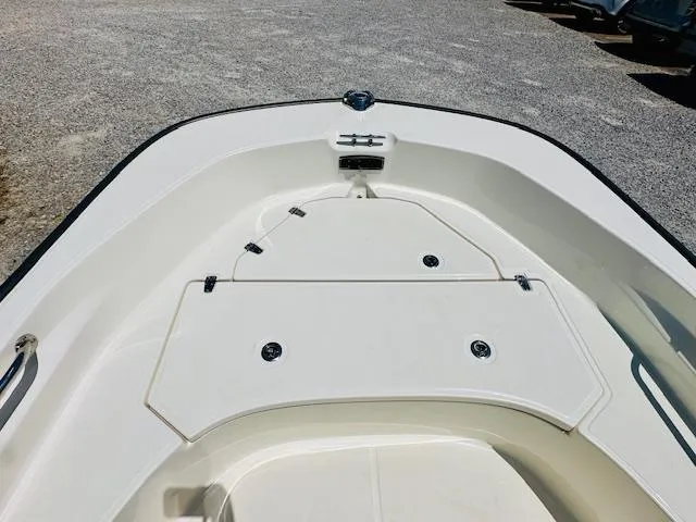 Slide: The Image of 2018 Boston Whaler 170 Montauk boat interior with storage compartments, parked on gravel. - 14