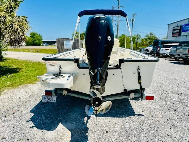 Slide: The Image of 2018 Boston Whaler 170 Montauk boat, rear view with outboard motor, parked on gravel. - 3