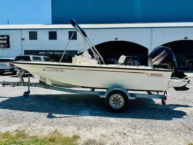 Slide: The Image of 2018 Boston Whaler 170 Montauk boat on trailer, parked outdoors near a building. - 5