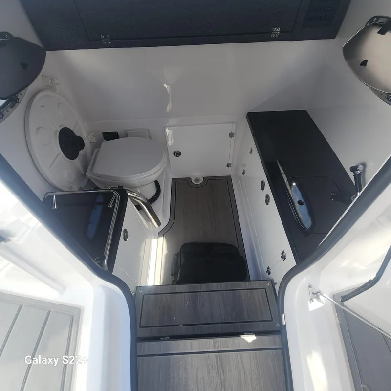 Slide: The Image of 2025 Monterey Elite 27 OB boat interior with compact bathroom and sink. - 11