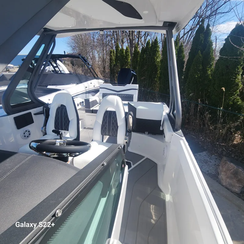 Slide: The Image of 2025 Monterey Elite 27 OB boat interior with modern seating and steering wheel. - 13