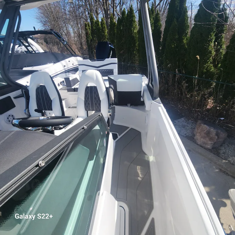 Slide: The Image of 2025 Monterey Elite 27 OB boat interior with white seating and modern design. - 14