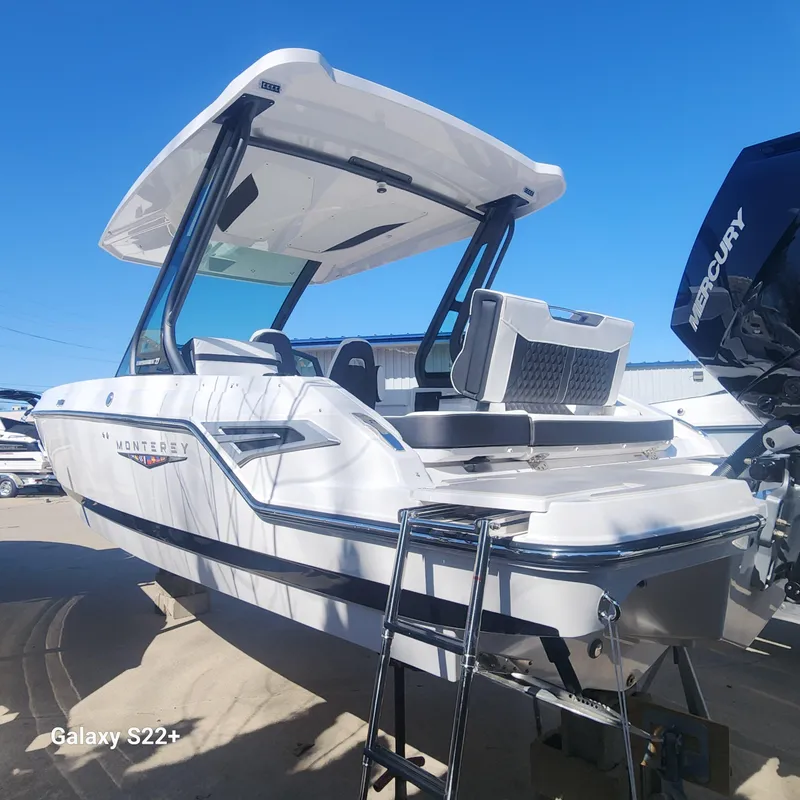 Slide: The Image of 2025 Monterey Elite 27 OB boat with Mercury engine, docked under clear blue sky. - 2