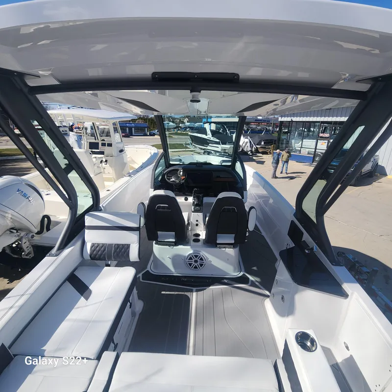 Slide: The Image of 2025 Monterey Elite 27 OB boat interior with seating and helm, docked at marina. - 4