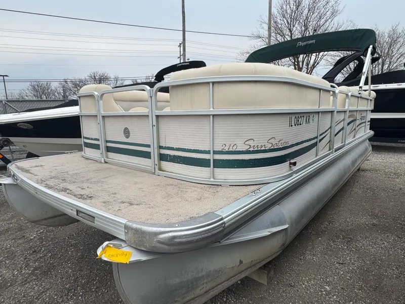 The Image of 2007 Premier 210 SunSation RE pontoon boat with green accents, parked on gravel. - 1