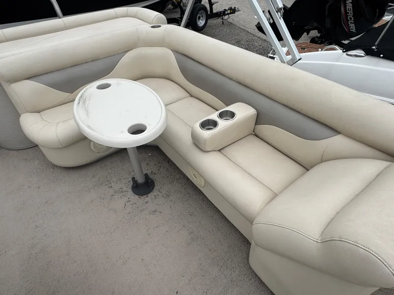 Slide: The Image of 2007 Premier 210 SunSation RE boat interior with beige seating and a round table. - 10