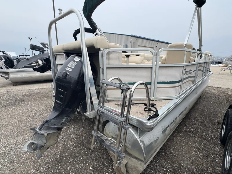 Slide: The Image of 2007 Premier 210 SunSation RE pontoon boat with outboard motor, parked on gravel. - 3