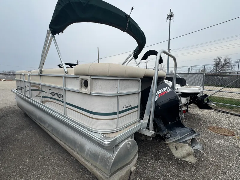Slide: The Image of 2007 Premier 210 SunSation RE pontoon boat with Suzuki outboard motor, parked on gravel. - 5