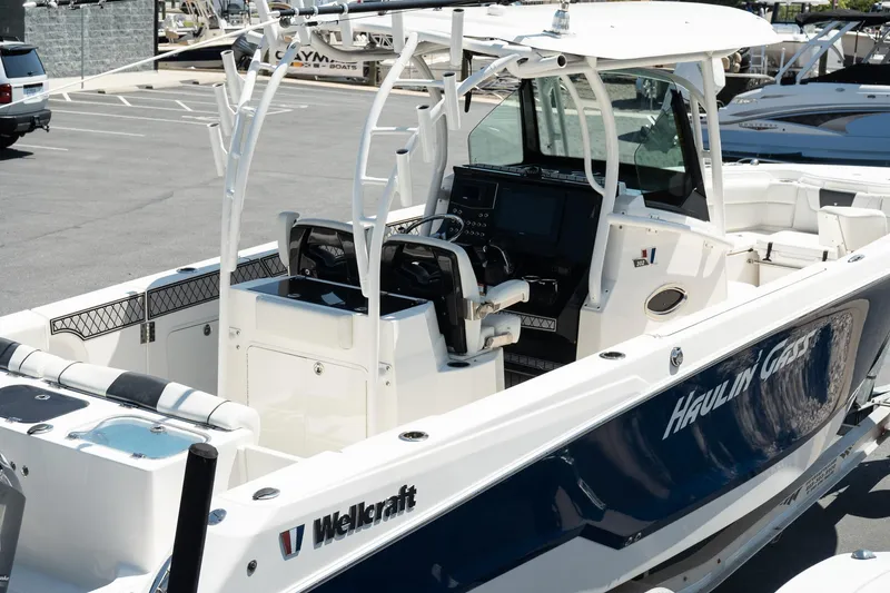 Slide: The Image of 2018 Wellcraft 302 Fisherman boat with sleek design and modern cockpit in a marina setting. - 11