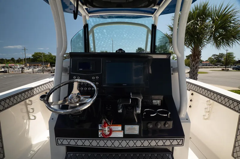 Slide: The Image of 2018 Wellcraft 302 Fisherman boat console with steering wheel and navigation controls. - 13