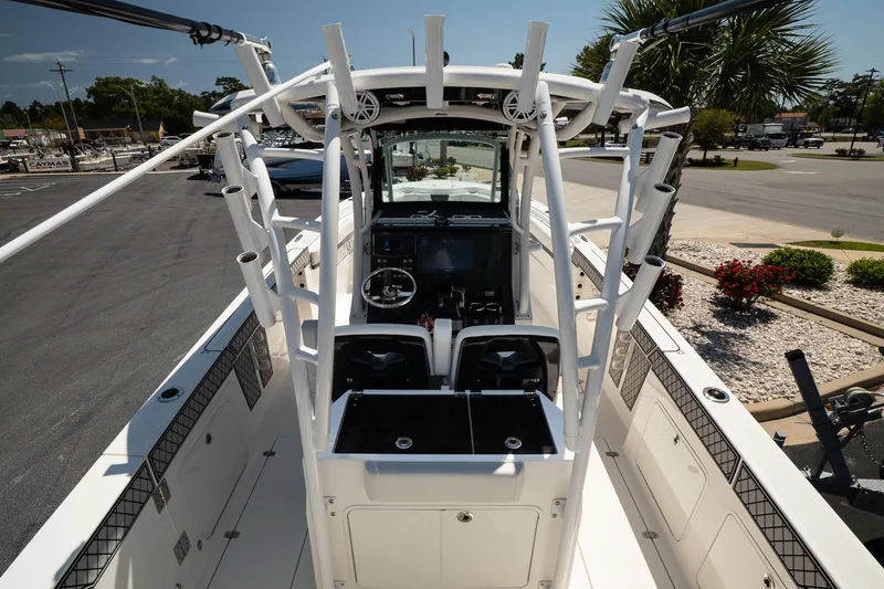 Slide: The Image of 2018 Wellcraft 302 Fisherman boat with center console and rod holders, parked outdoors. - 15