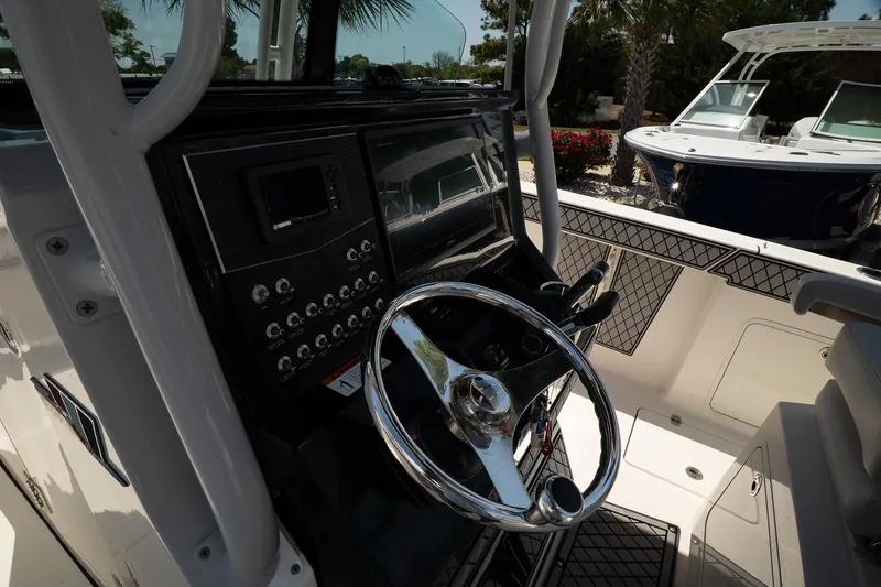 Slide: The Image of 2018 Wellcraft 302 Fisherman boat dashboard with steering wheel and control panel. - 18