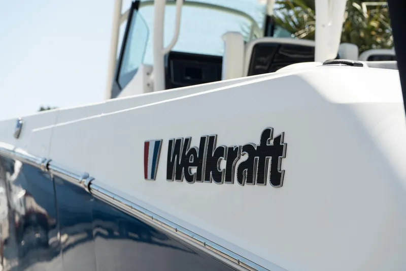 Slide: The Image of 2018 Wellcraft 302 Fisherman boat, close-up of logo on white and blue hull. - 7