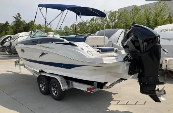 Slide: The Image of 2023 Crownline 260 XSS boat on trailer with outboard motor and canopy. - 1