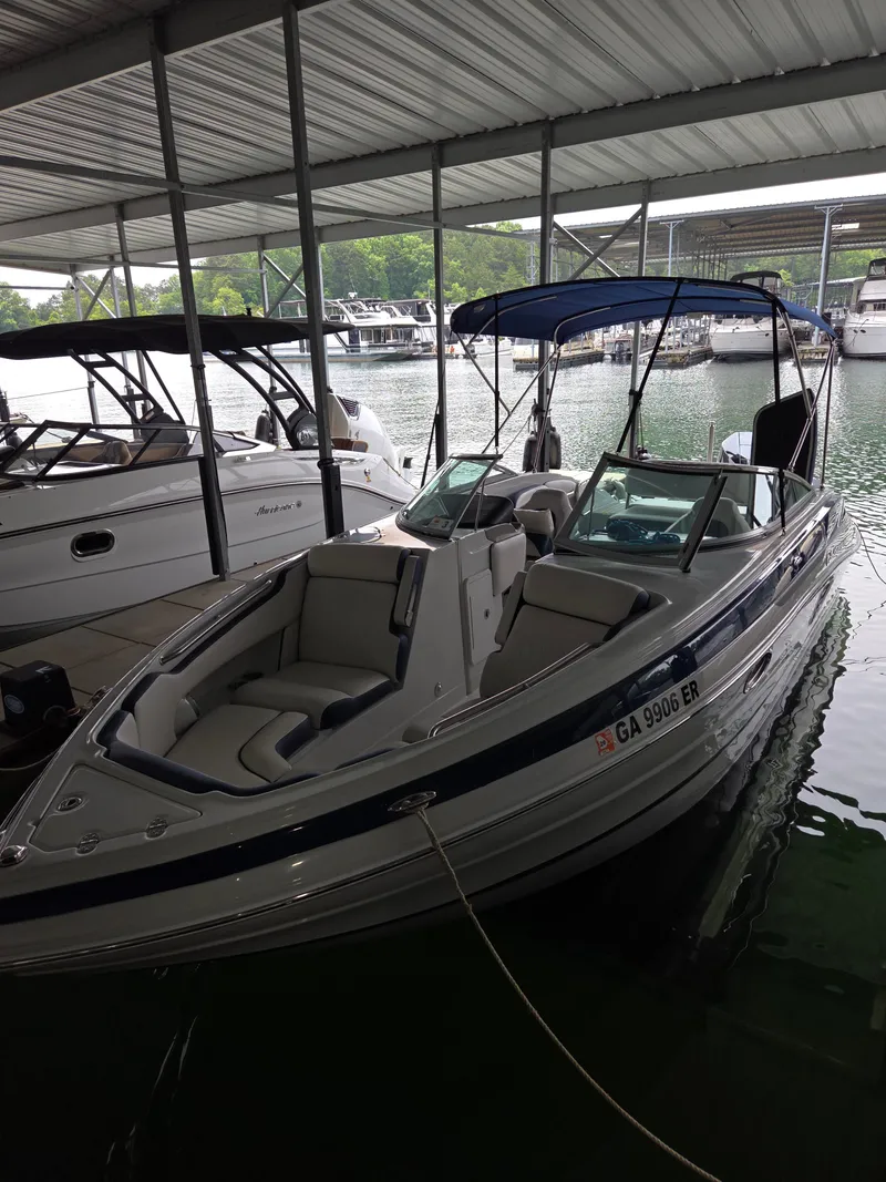 Slide: The Image of 2023 Crownline 260 XSS boat docked under a covered marina. - 11