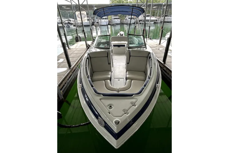 Slide: The Image of 2023 Crownline 260 XSS boat docked, featuring spacious seating and sleek design. - 15