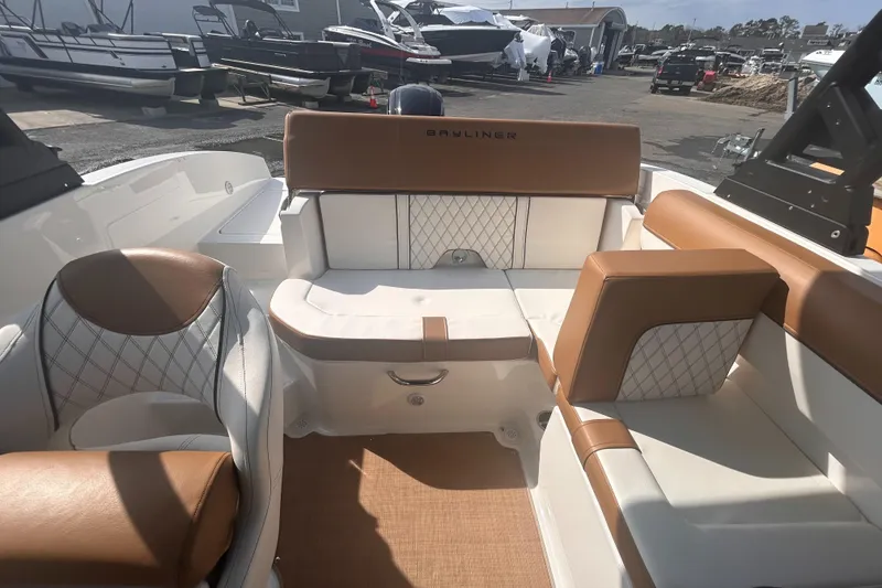 Slide: The Image of 2022 Bayliner DX2000 boat interior with tan and white seating, docked at a marina. - 4