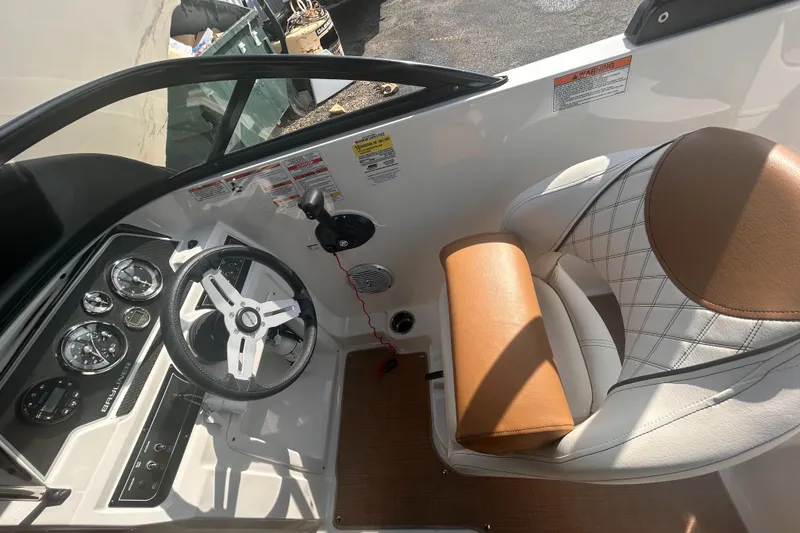 Slide: The Image of 2022 Bayliner DX2000 boat cockpit with steering wheel and cushioned seat. - 5