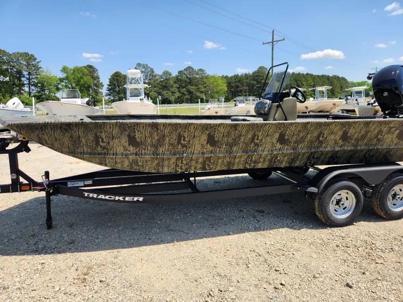 Slide: The Image of 2024 Tracker Grizzly 2072 CC boat on trailer, camo design, parked outdoors. - 6