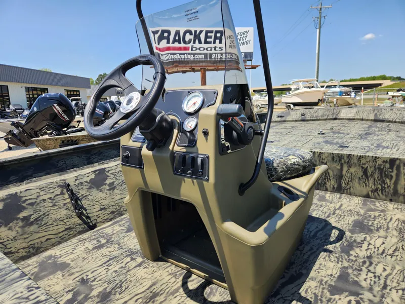Slide: The Image of 2024 Tracker Grizzly 2072 CC boat console with steering wheel and gauges, in a showroom. - 8