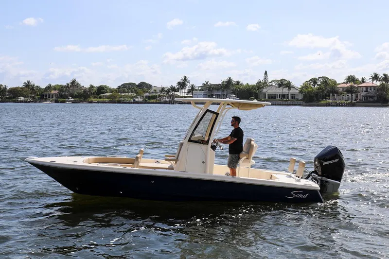 The Image of 2023 Scout 231 XSB boat cruising on a sunny day with a person at the helm. - 0