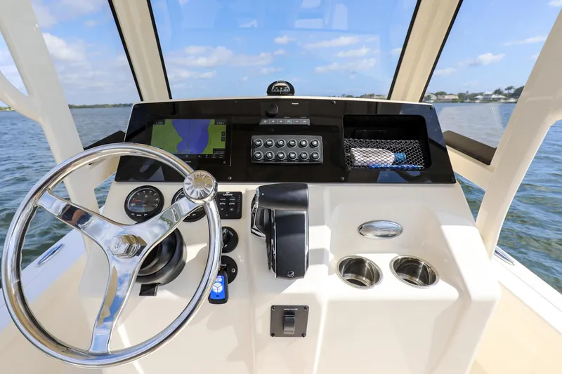 Slide: The Image of 2023 Scout 231 XSB boat dashboard with steering wheel and navigation controls. - 13