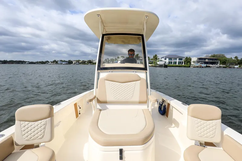 Slide: The Image of 2023 Scout 231 XSB boat on water, featuring beige seating and a center console. - 14