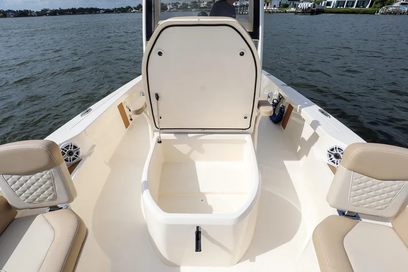 Slide: The Image of 2023 Scout 231 XSB boat interior with open storage compartment on calm water. - 16