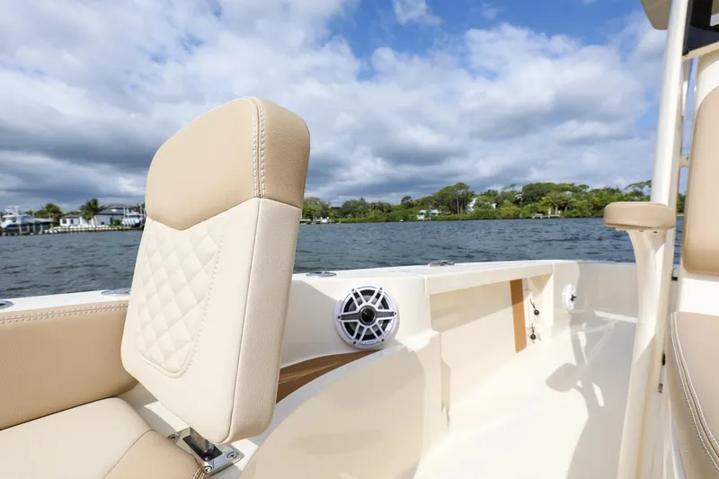 Slide: The Image of 2023 Scout 231 XSB boat interior with beige seating and water view. - 19