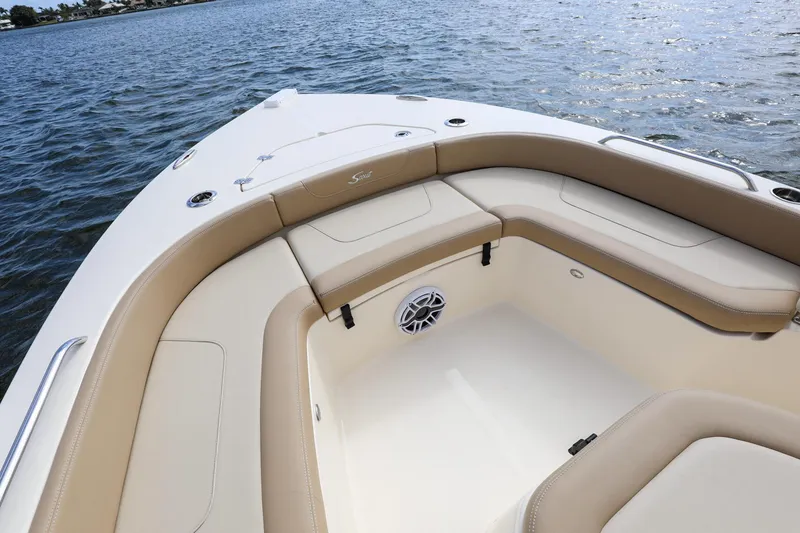 Slide: The Image of 2023 Scout 231 XSB boat interior with beige seating, on calm water. - 2