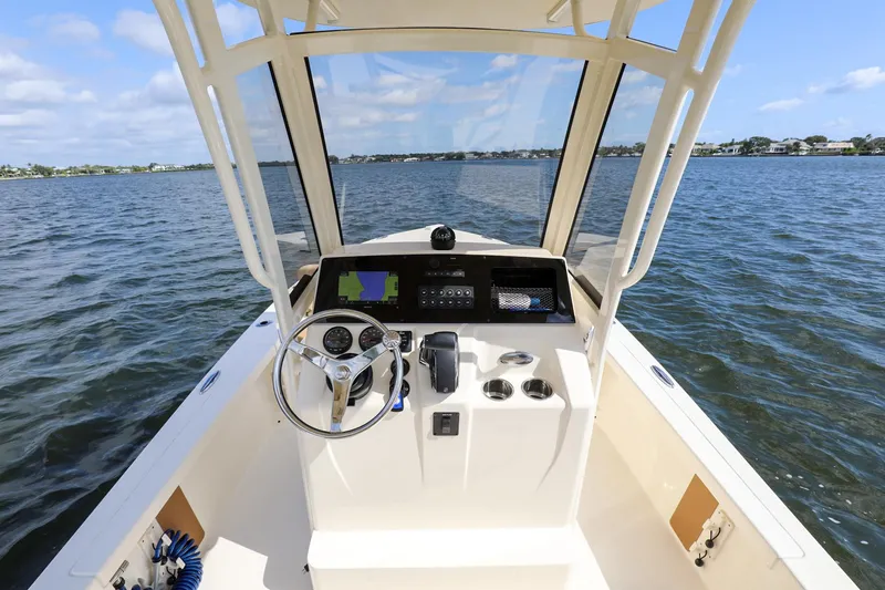 Slide: The Image of 2023 Scout 231 XSB boat dashboard with steering wheel on open water. - 20