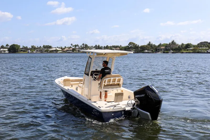 Slide: The Image of 2023 Scout 231 XSB boat cruising on a sunny day with a Mercury engine. - 24