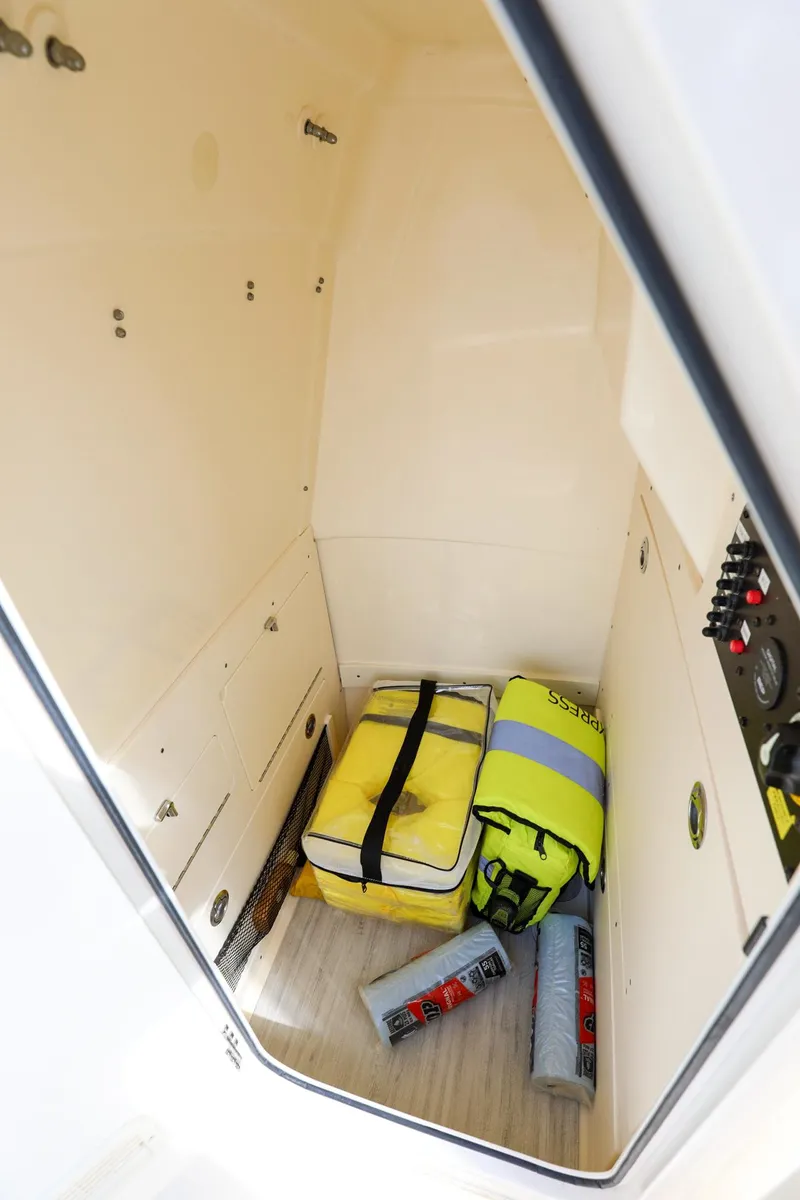 Slide: The Image of Storage compartment in 2023 Scout 231 XSB boat with safety gear and equipment. - 25