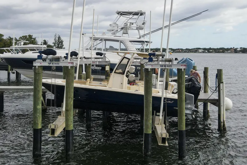 Slide: The Image of 2023 Scout 231 XSB boat docked on a lift by the water. - 31