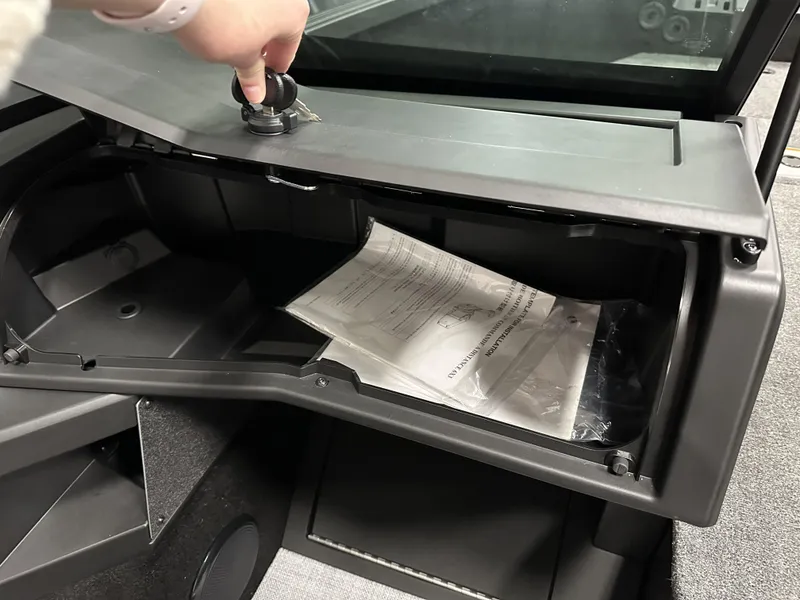 Slide: The Image of Glove compartment of 2025 Alumacraft Competitor 175X Sport boat, open with documents inside. - 10