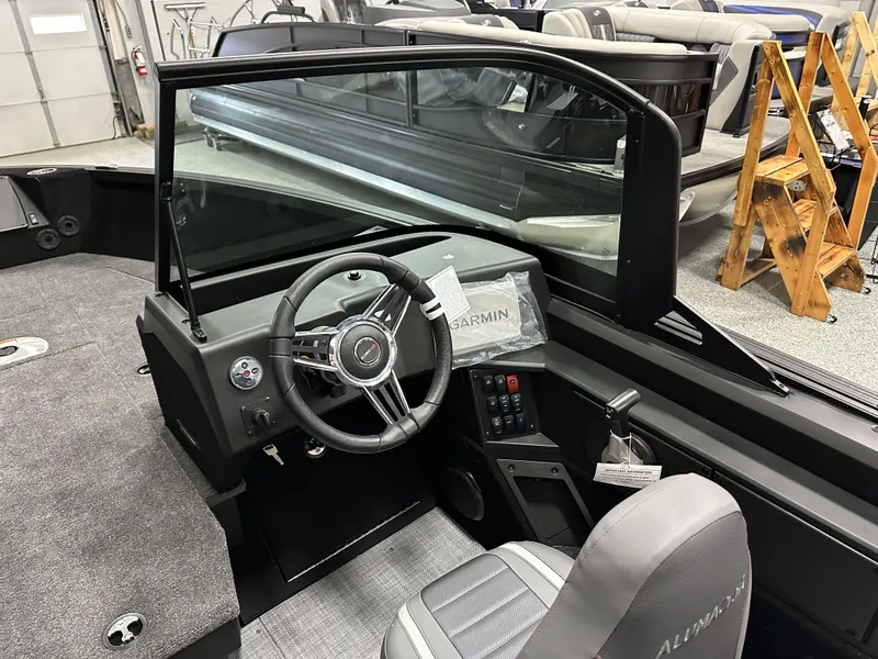 Slide: The Image of 2025 Alumacraft Competitor 175X Sport boat interior with steering wheel and Garmin display. - 11