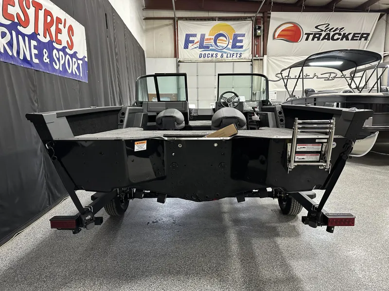 Slide: The Image of 2025 Alumacraft Competitor 175X Sport boat in showroom, rear view with ladder and seating. - 2