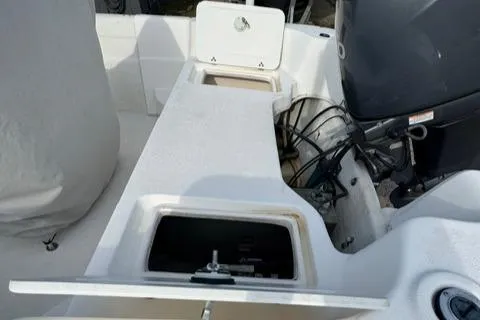 Slide: The Image of 2011 Carolina Skiff 198 DLV boat interior with open storage compartments and visible engine. - 16