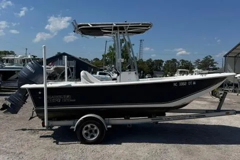 Slide: The Image of 2011 Carolina Skiff 198 DLV boat on trailer, parked outdoors under clear sky. - 5