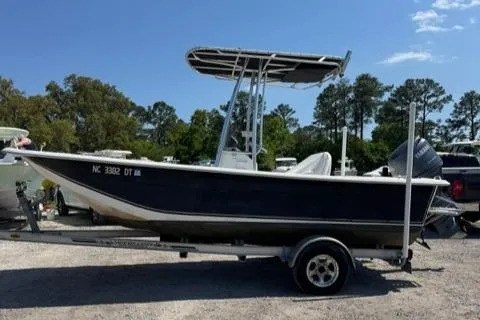 Slide: The Image of 2011 Carolina Skiff 198 DLV boat on trailer, parked outdoors under clear sky. - 8