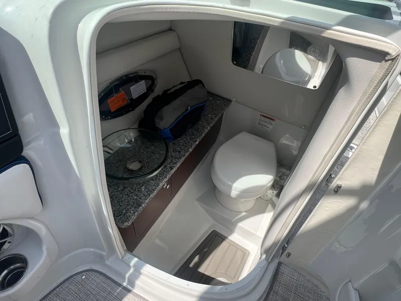 Slide: The Image of 2021 Crownline 255 SS boat interior with compact bathroom and modern amenities. - 12