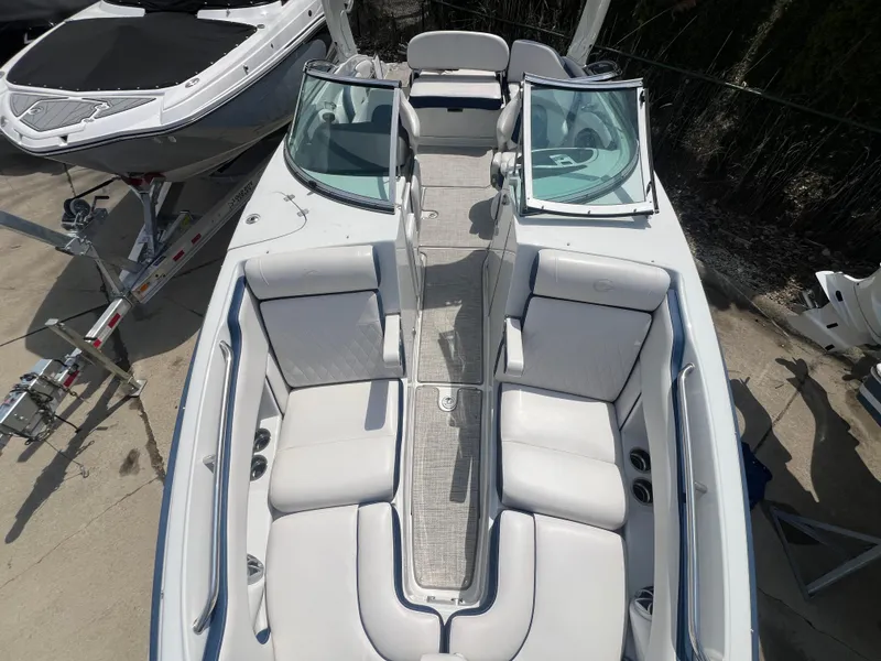 Slide: The Image of 2021 Crownline 255 SS boat with spacious seating and sleek design, docked outdoors. - 7