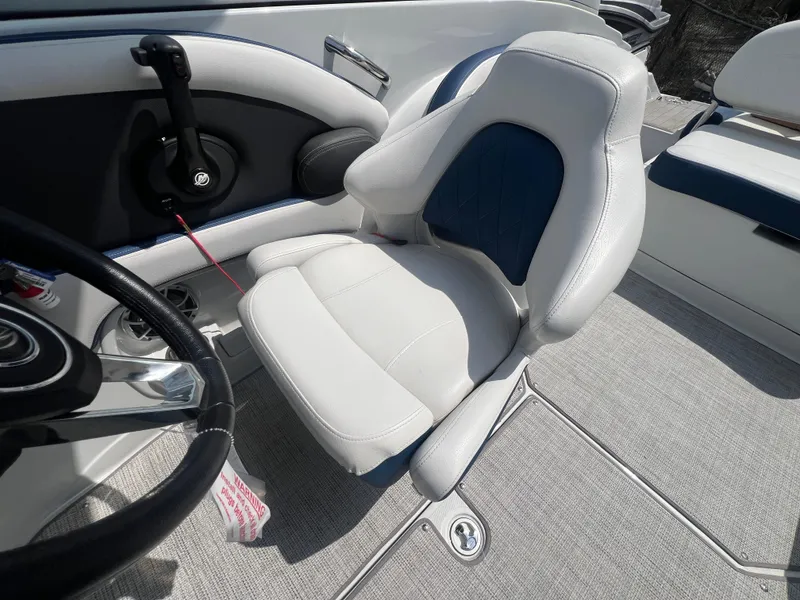 Slide: The Image of 2021 Crownline 255 SS boat interior with white and blue captain's seat. - 8