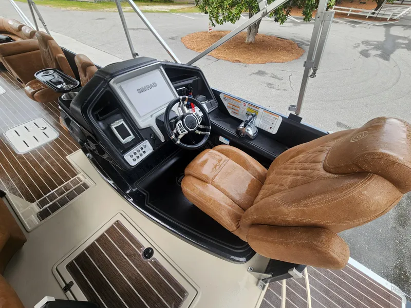 Slide: The Image of 2021 Premier 290 Grand View boat helm with brown leather seat and modern controls. - 11