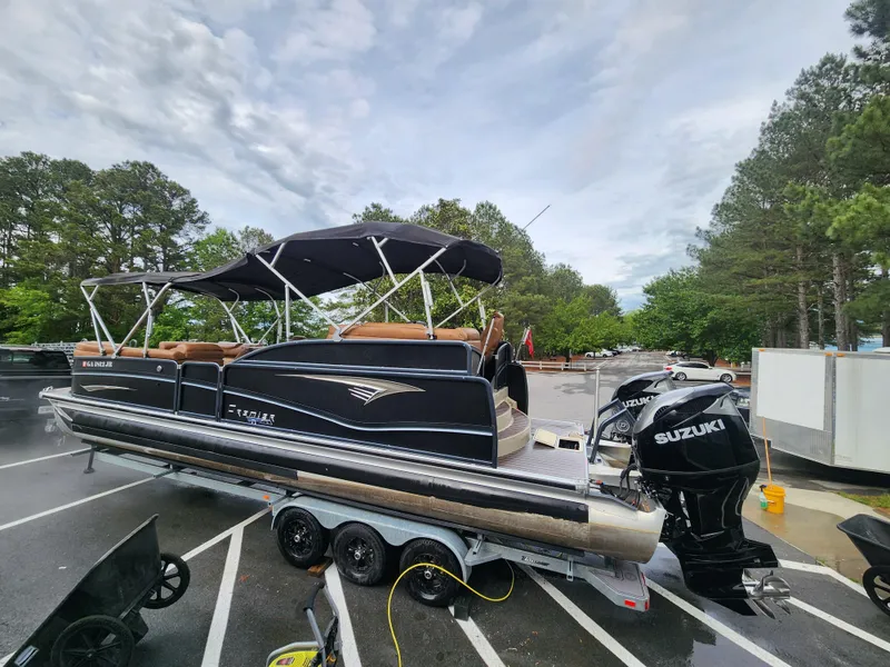 Slide: The Image of 2021 Premier 290 Grand View pontoon boat with Suzuki engine on trailer in parking lot. - 22