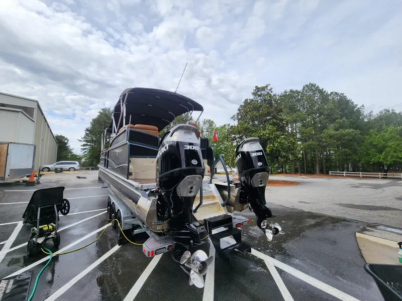 Slide: The Image of 2021 Premier 290 Grand View boat with dual 300 HP engines in a parking lot. - 23